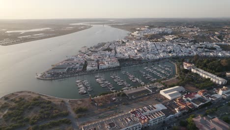 Aerial-backwards-view-of-coastal-town-of-Ayamonte-with-its-marina