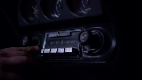 Man-hand-playing-with-an-old-Corvette-radio,-moving-dials-and-buttons