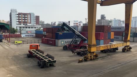 Crane-and-delivery-trucks-with-large-containers-at-Dhaka-inland-container-depot,-Bangladesh
