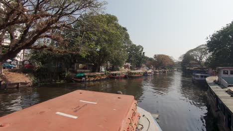 Tourist-boat-moving-along-navigable-canal-of-Alappuzha-or-Alleppey-in-India