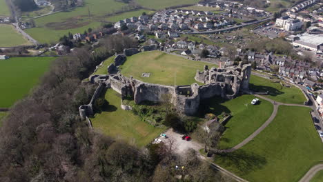 An-aerial-view-of-Denbigh-Castle-ruins-on-a-sunny-day,-flying-right-to-left-around-the-castle,-Denbighshire,-North-Wales,-UK
