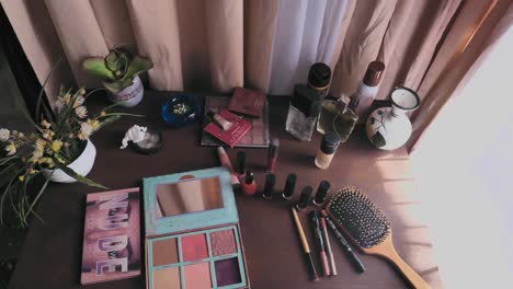 Beauty-Make-Up-Powder,-Nail-Polish-And-Hair-Brush-On-Dresser-Table-Beside-Curtain