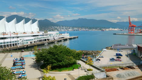 La-Gente-Se-Reúne-En-El-Parque-De-Puestos-De-Fotografía-De-Coal-Harbourview-Con-Vista-A-Canada-Place-Y-Burrard-Inlet-En-Vancouver,-Bc,-Canadá