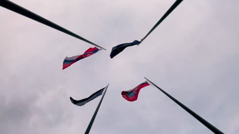 Slovakia-and-European-Union-flags-next-to-each-other-fluttering-in-wind-on-flagpole,-slow-motion-bottom-view
