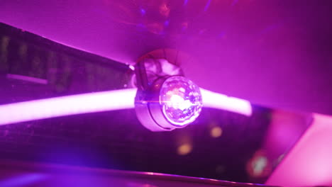 Small-disco-ball-lights-up-and-spins-inside-of-limo-with-pink-neon-light