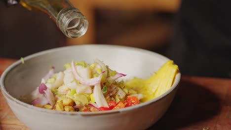 Preparation-of-Ceviche---cinematic-slow-motion-close-up-shot-of-a-chef-drizzling-extra-virgin-olive-oil-into-a-bowl-of-ingredients