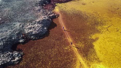 Gente-Caminando-En-Un-Campo-Hidrotermal-Abstracto-De-Color-Rojo,-Amarillo-Y-Gris-En-El-Lugar-Más-Caluroso-De-La-Tierra