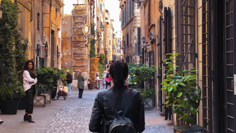 Slow-motion-shot-of-tourist-walking-between-old-historic-streets-of-Rome-during-sunlight