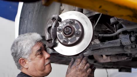 Old-Grizzled-Mexican-mechanic-Calibrating-the-brake-disc-of-a-car-recently-rectified-In-Tulum-Mexico