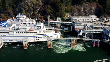 Ferry-Arrives-at-Ocean-Dock-to-Transport-Passengers-and-Cars,-Slow-Aerial-Pan