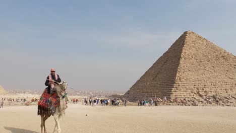 Touristen-Am-Fuß-Der-Menkaure-Pyramide-Mit-Kamelreiter,-Der-In-Ägypten-Vorbeigeht
