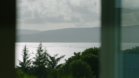 SAILING,-WINDOW-VIEW---two-sailing-boats-on-the-shimmering-Sound-of-Mull
