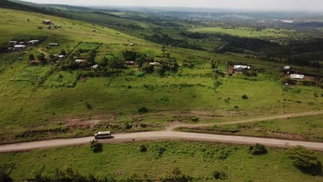 Amazing-drone-view-of-camper-truck-passing-countryside-scenery-in-Kenya,-Africa