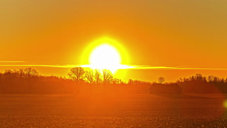 Statische-Aufnahme-Der-Sonne,-Die-Im-Zeitraffer-über-Der-Weide-Des-Bauern-Im-Morgengrauen-über-Dem-Gelben-Himmel-Aufgeht