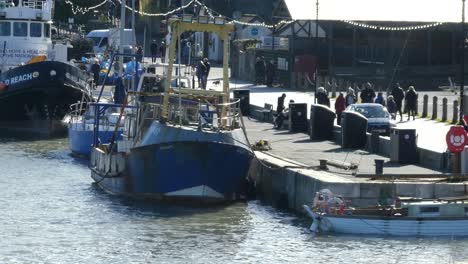 Scenic-Welsh-coastal-fishing-market-castle-town-harbour,-ships-anchored-on-waterfront