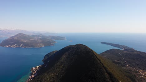 Vista-Aérea-Sobre-El-Pico-De-La-Montaña-En-La-Bahía-De-Kotor-En-Montenegro,-En-Un-Día-Claro-De-Verano