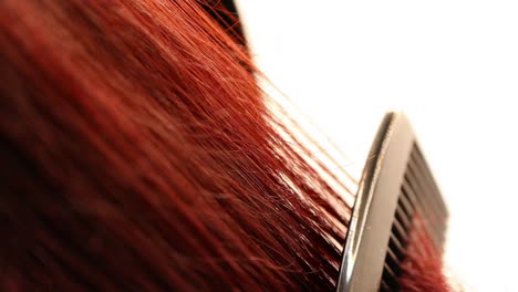 detail-of-combing-curly-red-hair,-macro-shot