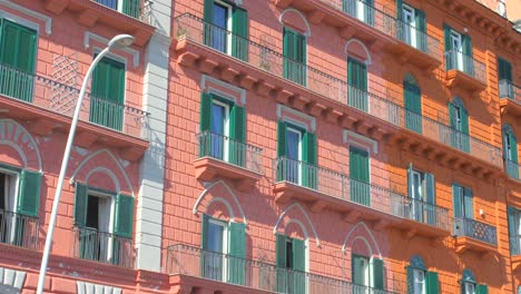 Low-angle-shot-of-old-historic-red-colored-building-in-Chiaia-district-in-Naples,-Italy-on-a-bright-sunny-day
