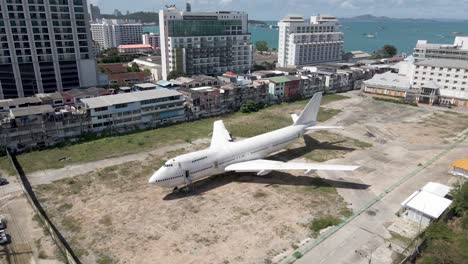 Aerial-pullback-from-White-old-Aircraft-parked-in-Pattaya-city-centre,-Runaway-88-street-project,-Thailand