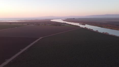 Salinas-River-turn-near-Castroville-surrounded-by-vast-agriculture-farmland,-aerial-drone-view