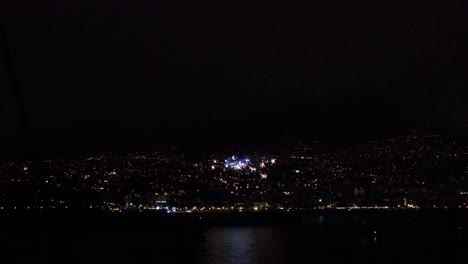 Stunning-drone-view-of-fireworks-at-the-shore-of-Funchal-city-in-Madeira,-Portugal