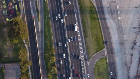 Rotating-drone-pov-over-cars-and-trucks-driving-on-General-Paz-motorway-in-Buenos-Aires,-Argentina