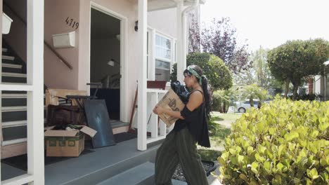 Woman-walking-with-a-box-of-stuff-moving-into-a-new-house
