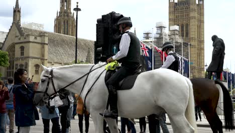 Traf-Polizisten-Auf-Pferden,-Die-Touristen-Auf-Dem-Geschlossenen-Parliament-Square-In-London-Begrüßten,-Während-Sie-Fotos-Machten