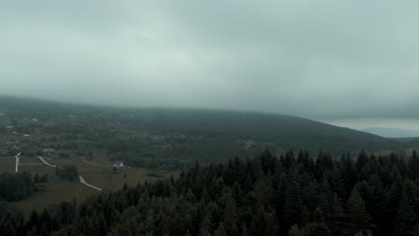 Aerial-shot-of-mountain-hotel-inside-of-misty-forest,-4k