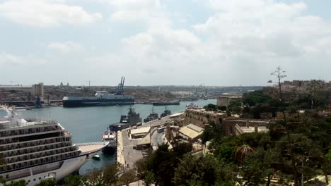 Grimaldi-Hybrid-RoRo-cargo-vessel-docked-in-Port-of-Valletta,-Malta-with-large-cruise-vessel-in-foreground