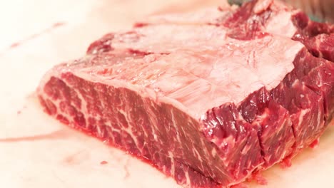 Butcher-cuts-a-large-pieces-of-selected-steak-meat
