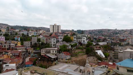 Aerial-orbit-of-seagulls-flying-over-Yugoslav-Path-in-Alegre-Hill,-colorful-Valparaiso-neighborhood,-Chile
