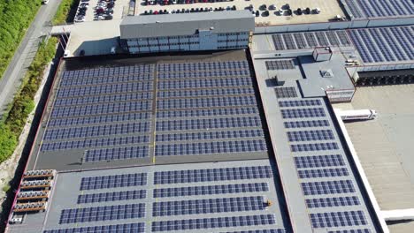 Huge-industrial-solar-installation-on-rooftop-of-Asko-Norway-in-Arna---7546-panels-in-arrays-on-industrial-warehouse-outside-Bergen---Upward-moving-aerial-with-tilt-down