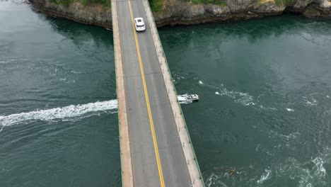 Aerial-shot-of-a-boat-passing-underneath-the-bridge-at-Deception-Pass