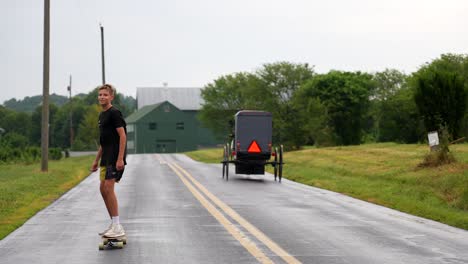 Amish-horse-and-buggy-passes-boy-skateboarding-on-back-country-road