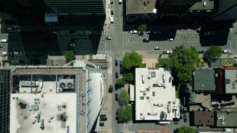 4K-Cinematic-urban-drone-footage-of-an-aerial-view-flying-over-buildings-and-boulevards-in-the-middle-of-downtown-Montreal,-Quebec-on-a-sunny-day-looking-down-from-a-bird's-point-of-view
