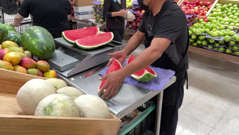 Zeitlupenaufnahme-Einer-Wassermelone,-Die-In-Einem-Obstladen-Geschnitten-Wird