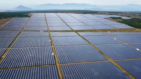 aerial-view-of-modern-solar-panel-plant-with-mountains-landscape-during-a-sunny-day-refill-the-electricity-in-big-smart-city-metropolis