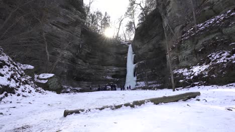 A-wide-shot-of-the-frozen-waterfall-at-Wildcat-Canyon-at-Starved-Rock-State-Park-with-a-sunstar