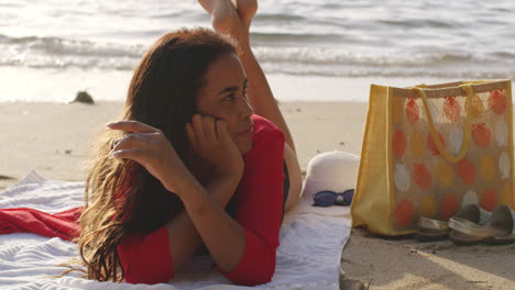 Brunette-Latin-Woman-on-Tropical-Beach-Seashore-Lying-on-Front-Relaxing-in-Sunshine,-medium-Shot