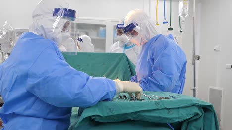 Asian-Doctor-Wear-Infection-Control-Gown-Perform-Surgery-In-Operating-Room