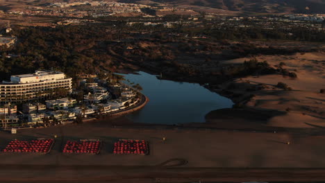 Increíble-Vista-Aérea-De-Drones-De-Una-Ciudad-Junto-Al-Mar-Rodeada-De-Playa-De-Arena-En-La-Isla-De-Gran-Canaria-Maspalomas-En-España