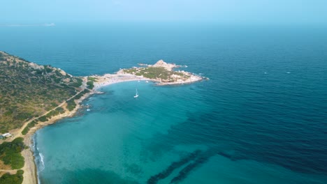 Klares-Blaues-Türkis-Und-Ruhiges-Wasser-An-Einer-Natürlichen-Sandstrandküstenbucht-In-Sardinien,-Italien-Mit-Sonne-Und-Segelschiff
