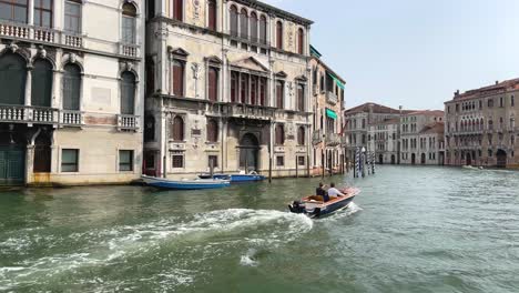 Two-Wealthy-Men-In-Motor-Boat-Sightseeing-Venice,-Italy-On-Grand-Canal