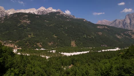 Valley-of-Valbona-in-Albania,-beautiful-riverbed-and-green-forests-under-alpine-mountains