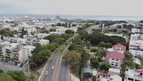 Drone-view-of-Mirador-Park-in-the-background-of-the-great-city-of-Santo-Domingo,-quiet-area-of-the-city-with-green-area
