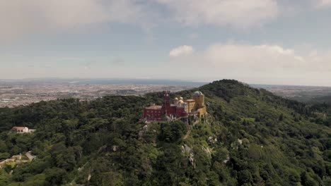 Spectacular-panoramic-shot-of-Sintra-hills-sky-castle,-mountaintop-Pena-palace-with-cloudscape