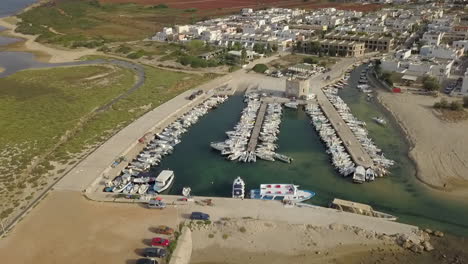 Aerial-circling-over-touristic-port-of-Torre-Pali-in-Puglia,-Italy