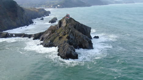 Aerial-zoom-out-shot-Gaztelugache-is-an-islet-in-the-Vizcaya-town-of-Bermeo,-Pais-Vasco,-Spain