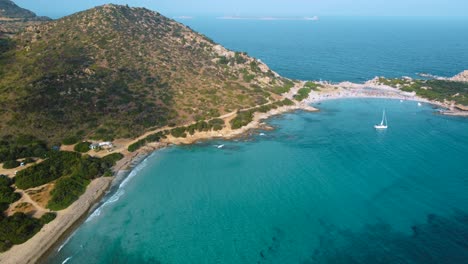 Sardinien-Klares-Blaues-Türkis-Und-Ruhiges-Wasser-An-Einer-Natürlichen-Sandstrandküstenbucht-In-Italien-Mit-Sonne-Und-Segelboot